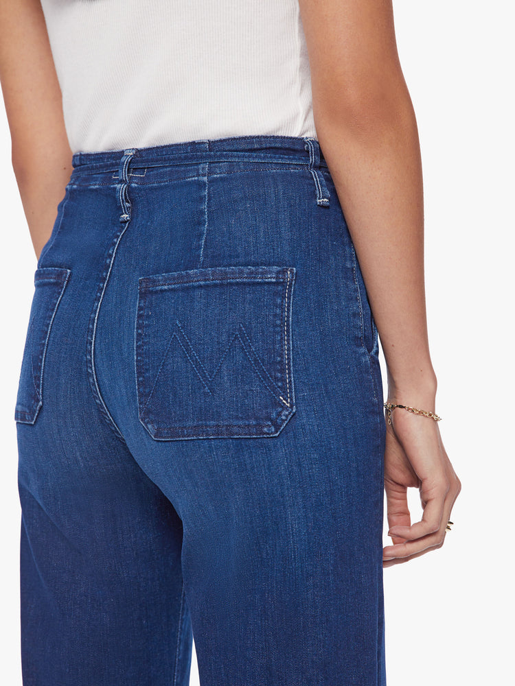 Back close up view of a women super high-waisted jeans with a loose fit, slit pockets, tied waist and 34-inch inseam with a clean hem.