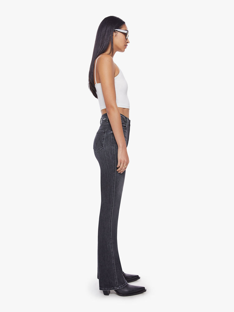 Side view of a woman highest-rise flare with a narrow leg and 34-inch inseam in a washed black hue.