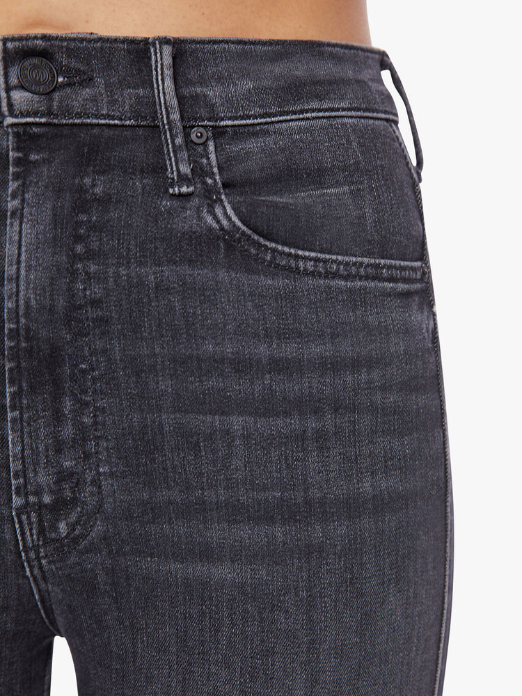 Waist front close up view of a woman highest-rise flare with a narrow leg and 34-inch inseam in a washed black hue.