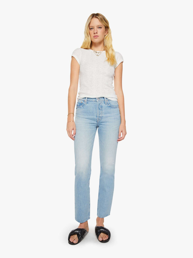 Front view of a woman in a light blue high-waisted straight-leg jeans with a button fly, 31-inch inseam and a clean hem.