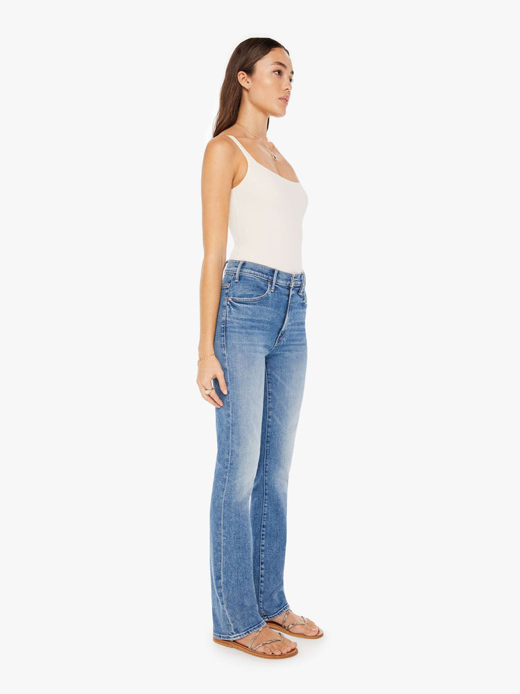 Front 3/4 view of a womens medium blue wash jean featuring a high rise and a flare leg.