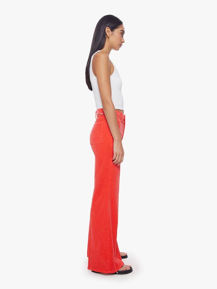Side view of a woman wide-leg pants with a high rise, long inseam, patch pockets and a clean hem in a bright orange-red hue.