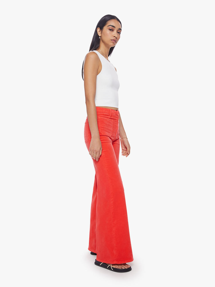 Side angle view of a woman wide-leg pants with a high rise, long inseam, patch pockets and a clean hem in a bright orange-red hue.