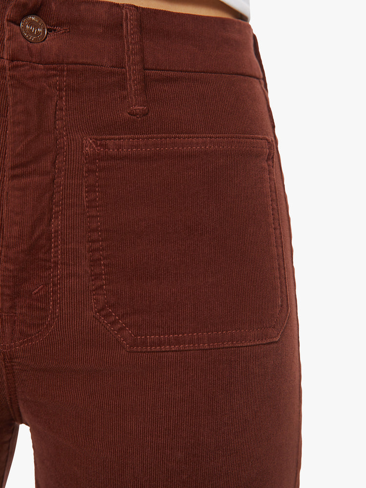 Waist close up view of a woman wide-leg pants with a high rise, long inseam, patch pockets and a clean hem in a maroon-brown hue.