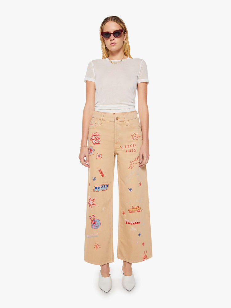 Front view of a woman in a khaki with colorful embroidery  wide-leg jeans are designed with a loose fit, button fly and a 30-inch inseam with a clean hem.  