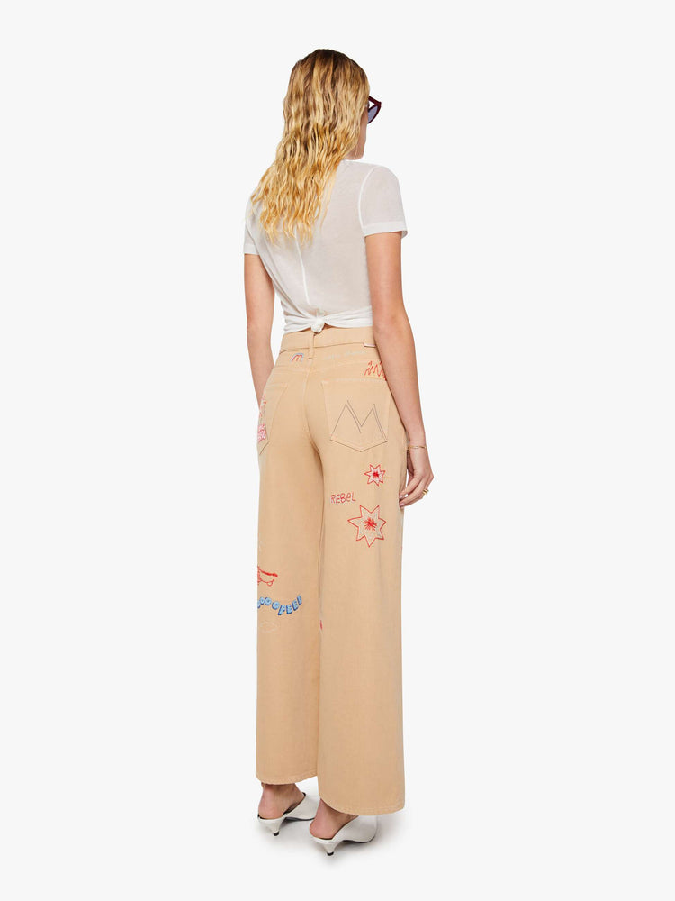 Back view of a woman in a khaki with colorful embroidery  wide-leg jeans are designed with a loose fit, button fly and a 30-inch inseam with a clean hem.  