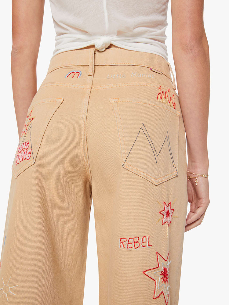 Back view of a woman in a khaki with colorful embroidery  wide-leg jeans are designed with a loose fit, button fly and a 30-inch inseam with a clean hem.  