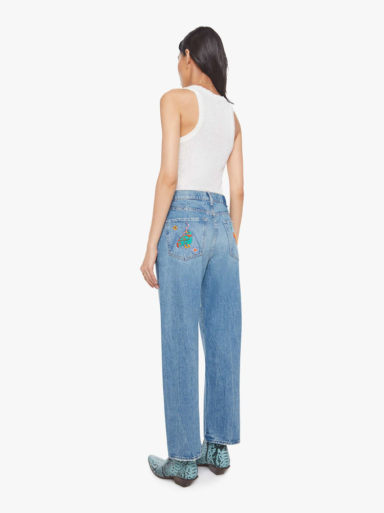 Back view of a woman in jeans designed to sit on the hips with a slouchy fit, a loose straight leg, zip fly and a 28.25-inch inseam with a clean hem.