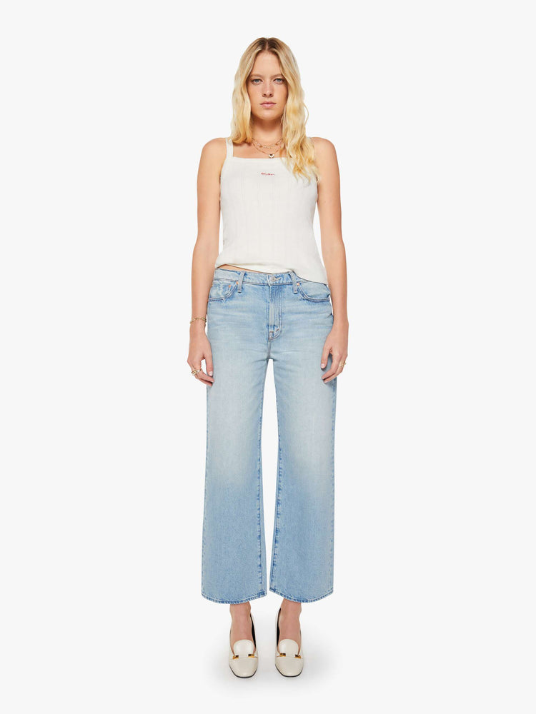 Front view of a woman in light blue jeans designed to sit on the hips with a slouchy fit, a loose straight leg, button fly and a 28.25-inch inseam with a clean hem.