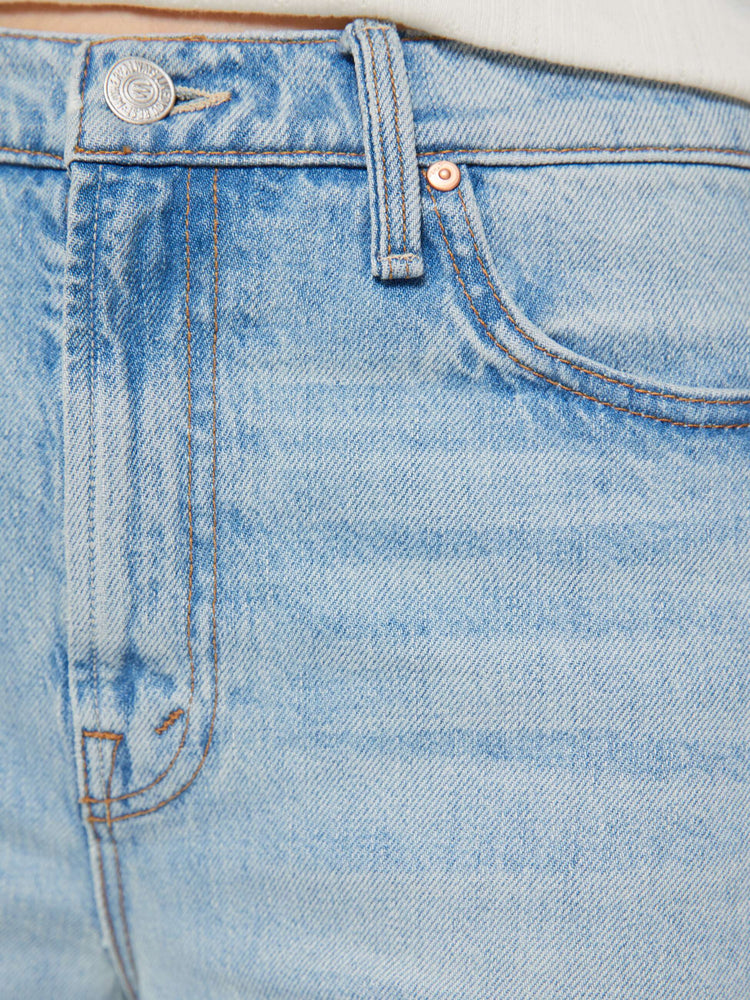 Swatch view of a woman in light blue jeans designed to sit on the hips with a slouchy fit, a loose straight leg, button fly and a 28.25-inch inseam with a clean hem.