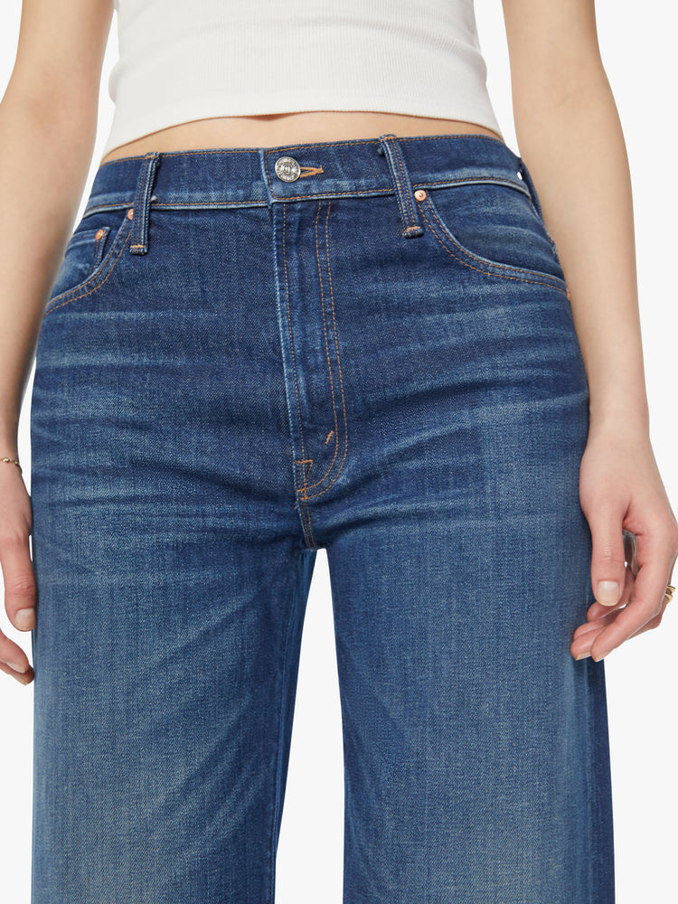 Waist view of a woman high-waisted jean with a loose wide leg, 28.25-inch inseam and a clean hem in a dark blue wash.