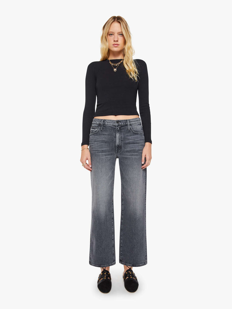 Front view of a woman in a dark grey Jeans designed to sit on the hips with a slouchy fit, a loose straight leg, button fly and a 28.25-inch inseam with a clean hem.
