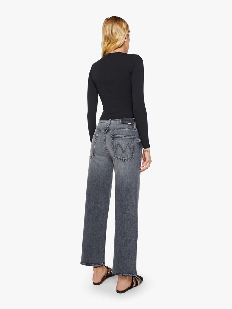 Back view of a woman in a dark grey Jeans designed to sit on the hips with a slouchy fit, a loose straight leg, button fly and a 28.25-inch inseam with a clean hem.