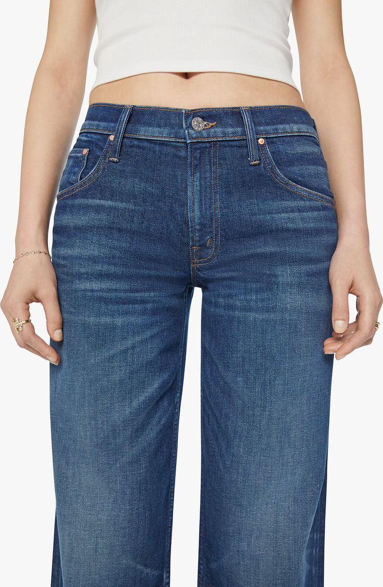 Waist view of a woman low-rise jeans with a loose wide leg, button fly and a long 34-inch inseam with a clean hem in a dark blue wash.