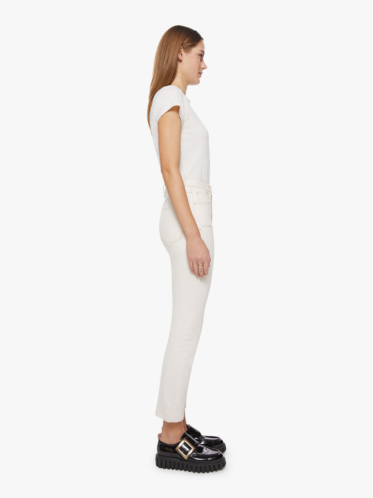 Side view of a woman white jean with high-rise straight leg with Western-inspired yoke details at the waist, an ankle-length inseam and a clean hem.