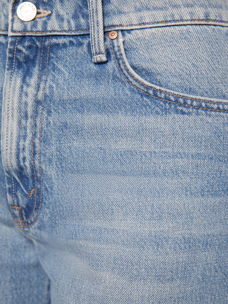 Close up detail view of a light blue wash jean with subtle whiskering.