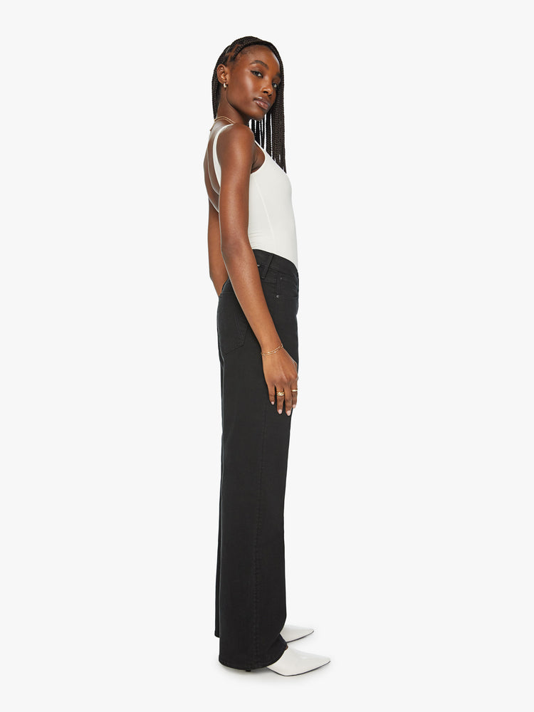 Side view of a woman high waisted jean with a loose wide leg and long 32 inch inseam in a black wash.