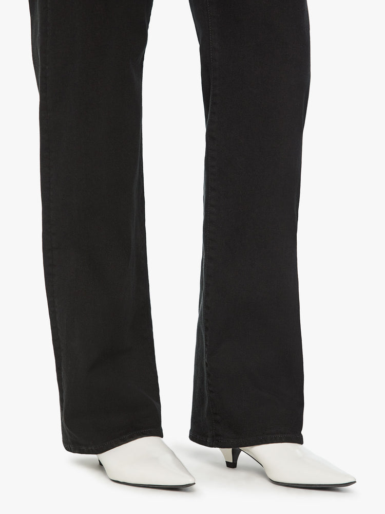 Hem view of a woman high waisted jean with a loose wide leg and long 32 inch inseam in a black wash.