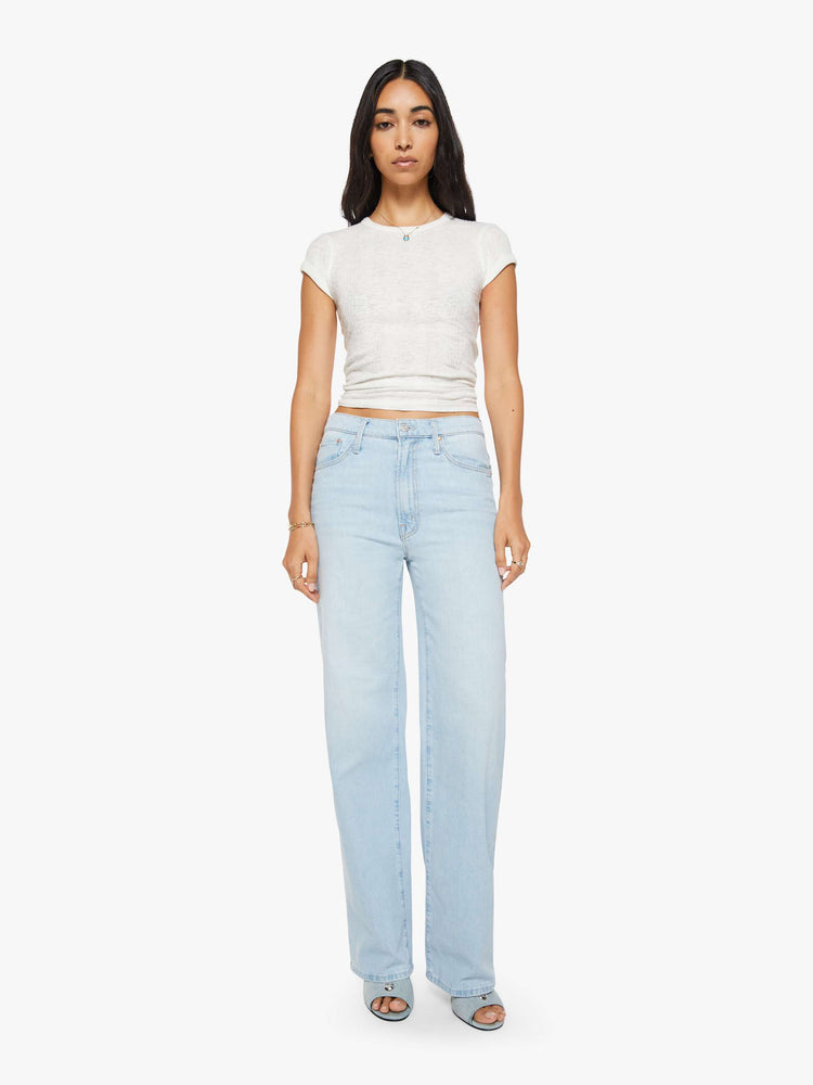 Front view of a woman in a light blue jeans designed to sit on the hips with a zip fly, slouchy fit, loose straight leg and a 32-inch inseam with a clean hem. 