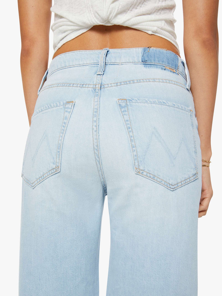 Close up view of a woman in a light blue jeans designed to sit on the hips with a zip fly, slouchy fit, loose straight leg and a 32-inch inseam with a clean hem.