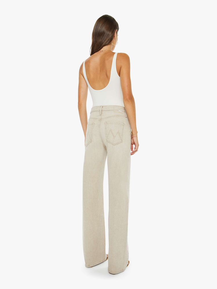 Back view of a woman in a faded khaki with tan stitching jeans designed to sit on the hips with a zip fly, slouchy fit, loose straight leg and a 32-inch inseam with a clean hem.