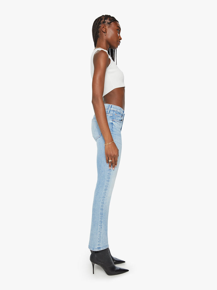 Side view of a woman light blue mid-rise bootcut has a 29.25-inch inseam and a clean hem.