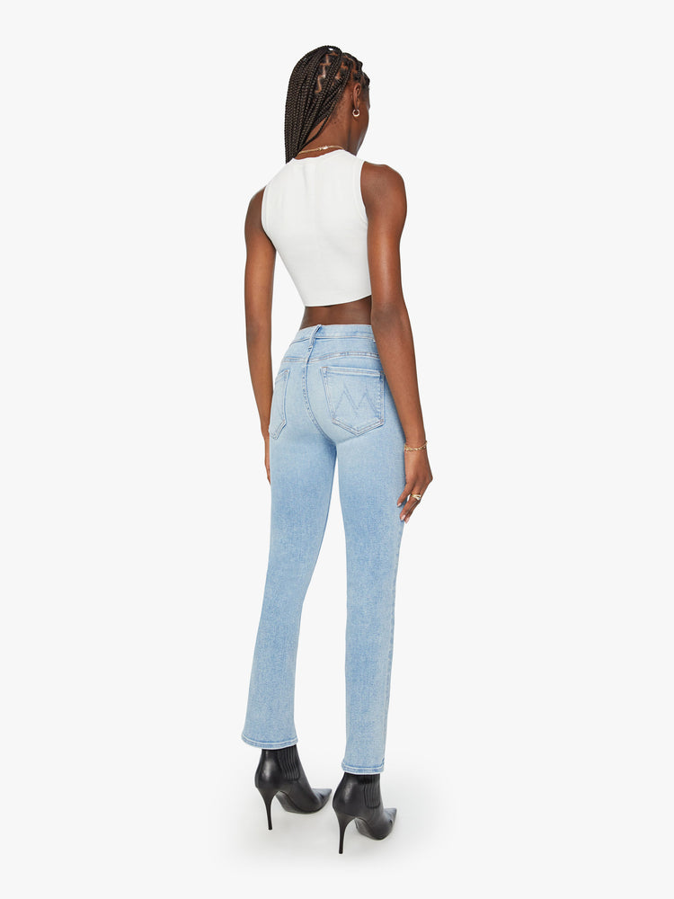 Back view of a woman light blue mid-rise bootcut has a 29.25-inch inseam and a clean hem.