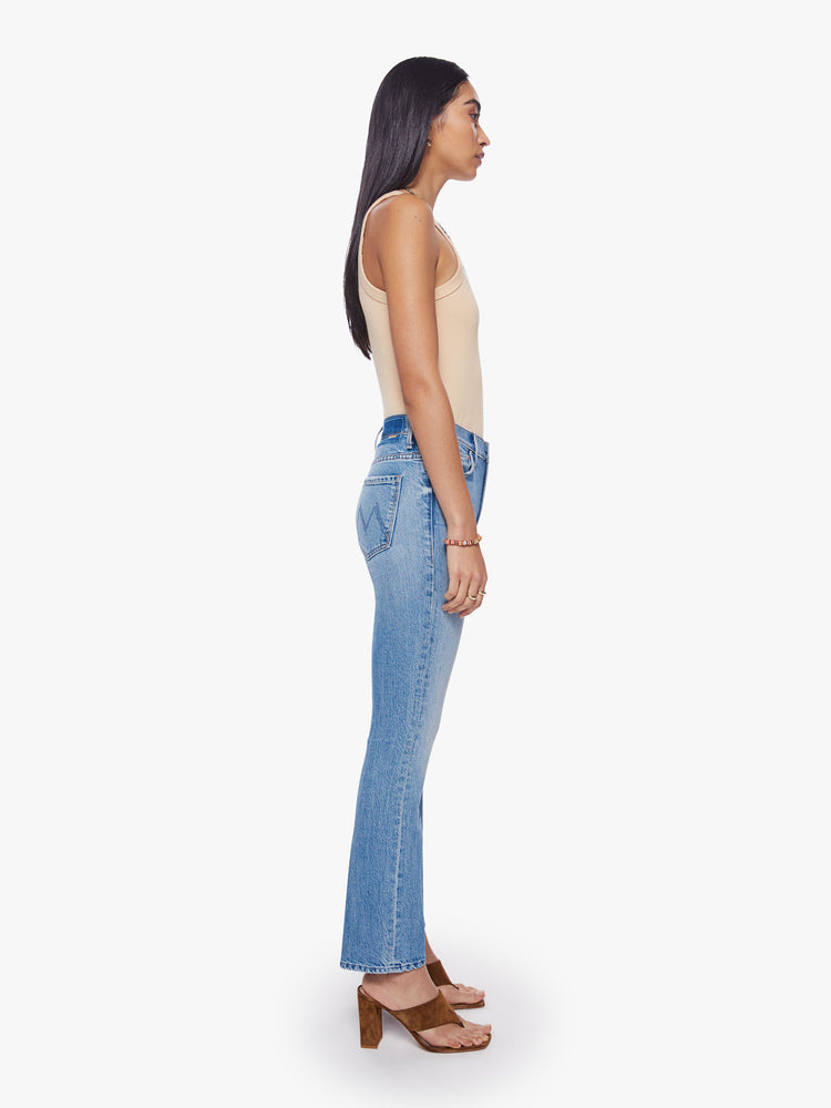 Side view of a woman mid-rise bootcut has a 28.25-inch inseam and a clean hem in a vintage blue wash.