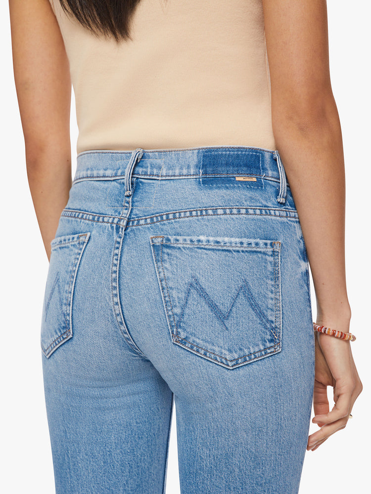 Close up back view of a woman mid-rise bootcut has a 28.25-inch inseam and a clean hem in a vintage blue wash.