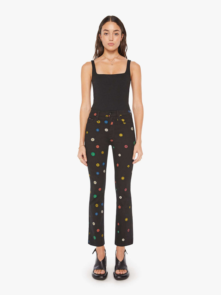 Front view of a woman high-rise bootcut has a 28.25-inch inseam and a clean hem in a black with flowers throughout.