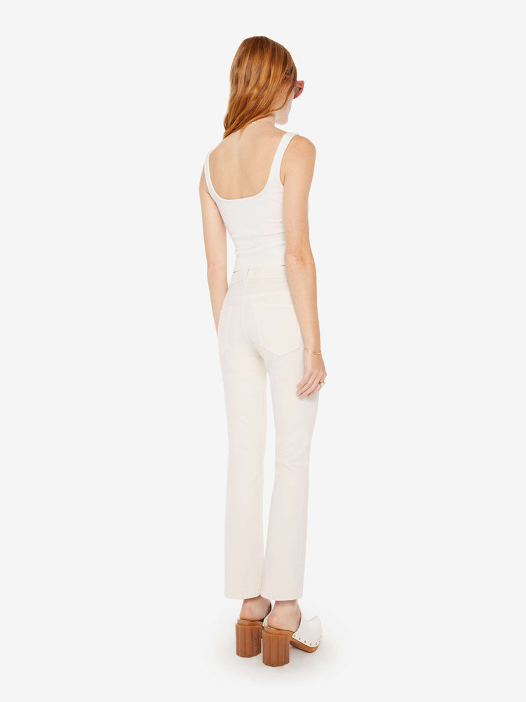 Back view of a woman light khaki cream colored high-rise bootcut has a 28.25-inch inseam and a clean hem pant.