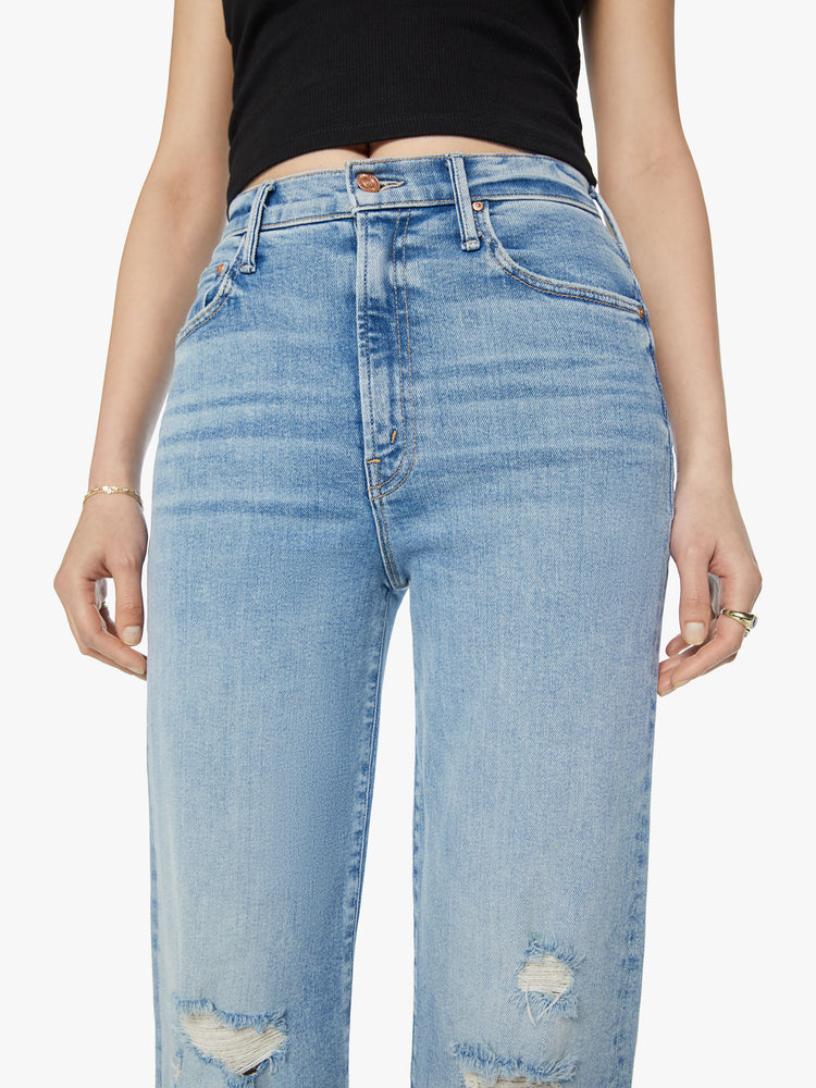Waist close up view of a woman super high-waisted jeans with a loose fit, wide leg and 31-inch inseam with a clean hem in a light blue wash.
