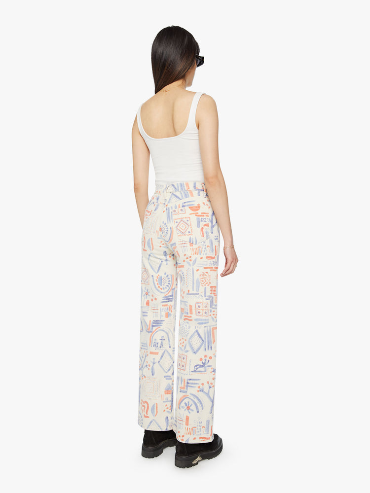 Back view of a woman super high-waisted pants with a loose fit, wide leg and 31-inch inseam with a clean hem in an off white with doodles in red and blue.