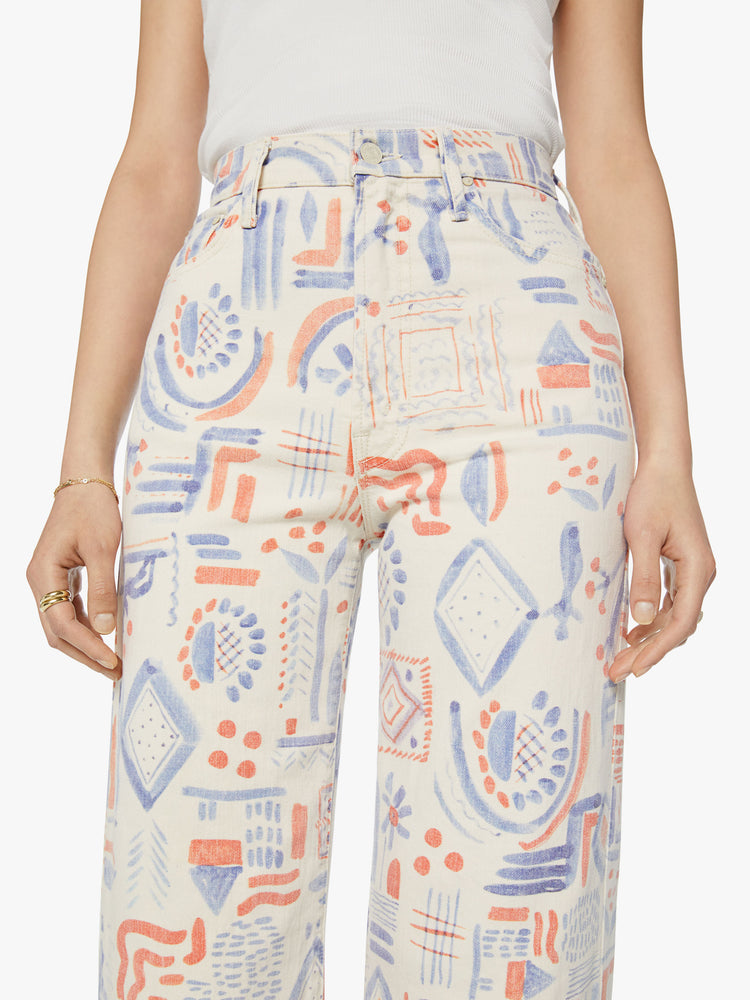 Waist view of a woman super high-waisted pants with a loose fit, wide leg and 31-inch inseam with a clean hem in an off white with doodles in red and blue.