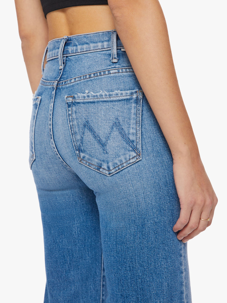 Back close up view of a woman wide-leg jeans with a high rise, ankle-length inseam and a clean hem in a light blue wash.