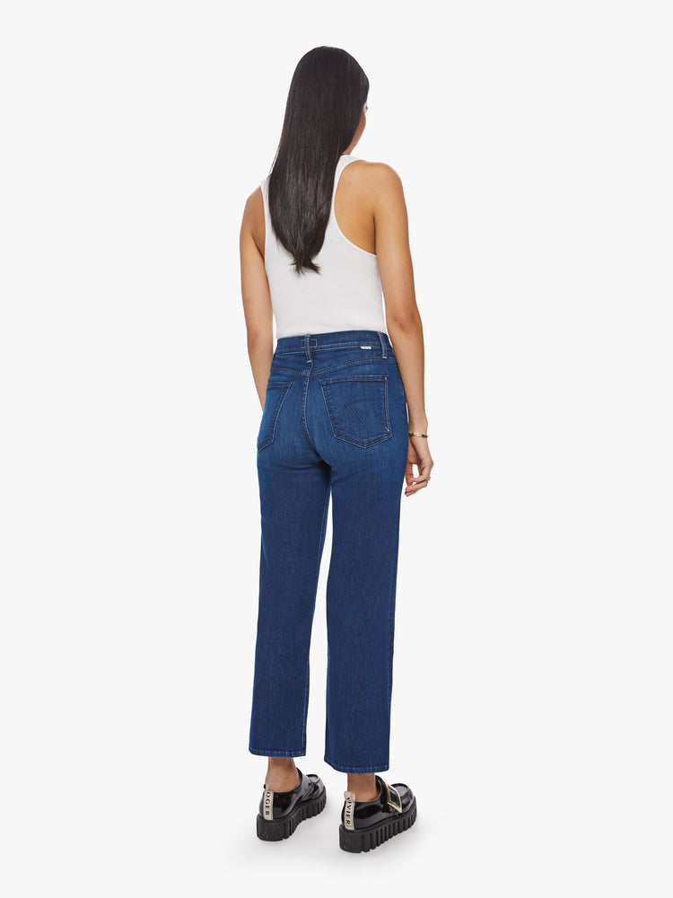 Back view of a woman high-waisted jeans with a wide straight leg, zip fly and clean ankle-length inseam in dark blue wash.