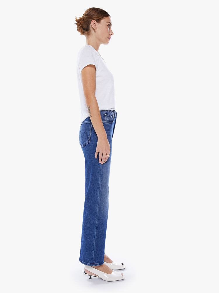 Side view of a woman high-waisted jean with a wide straight leg, zip fly and clean ankle-length inseam in an ocean-blue hue.