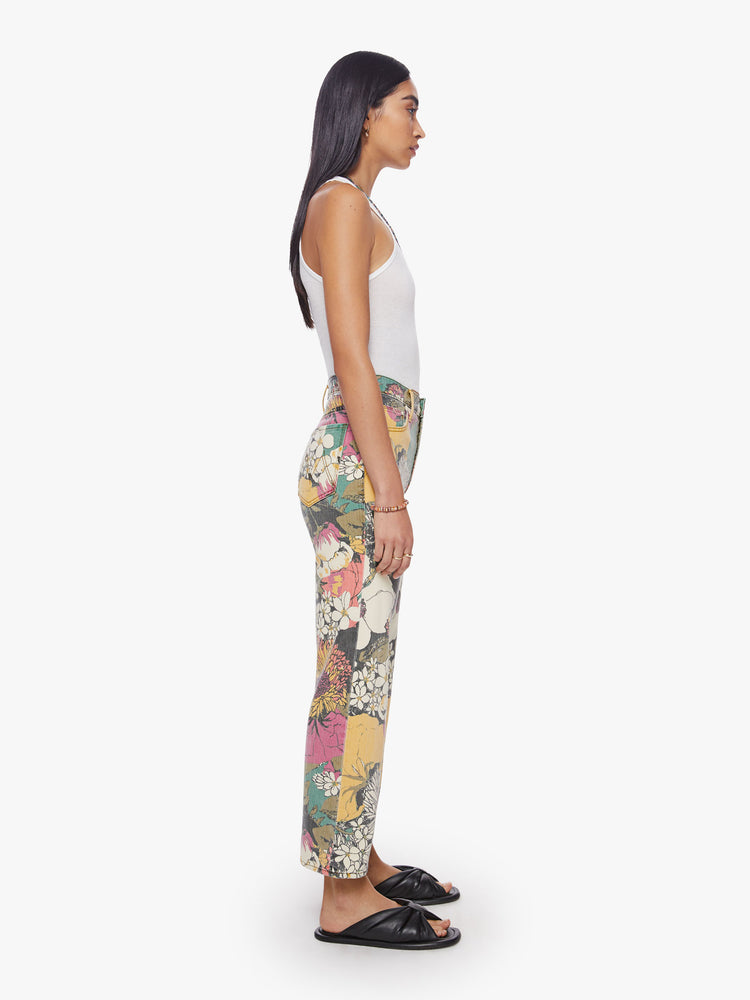 Side view of a woman high-waisted jeans with a wide straight leg, zip fly and clean ankle-length inseam in an oversized floral print.