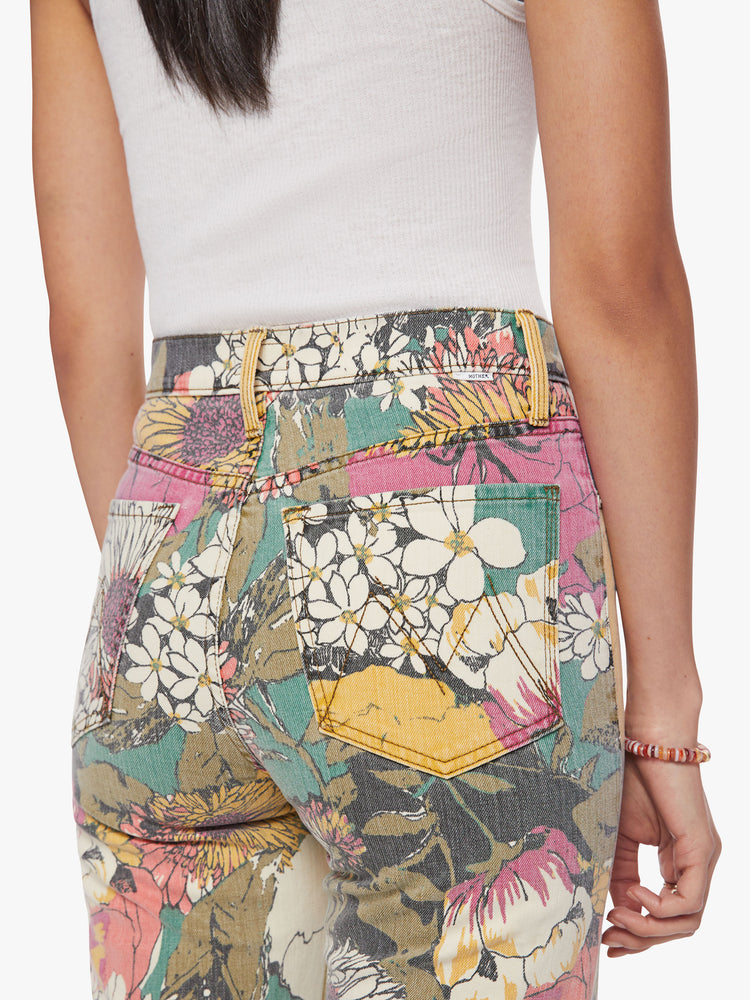 Close up view of a woman high-waisted jeans with a wide straight leg, zip fly and clean ankle-length inseam in an oversized floral print.