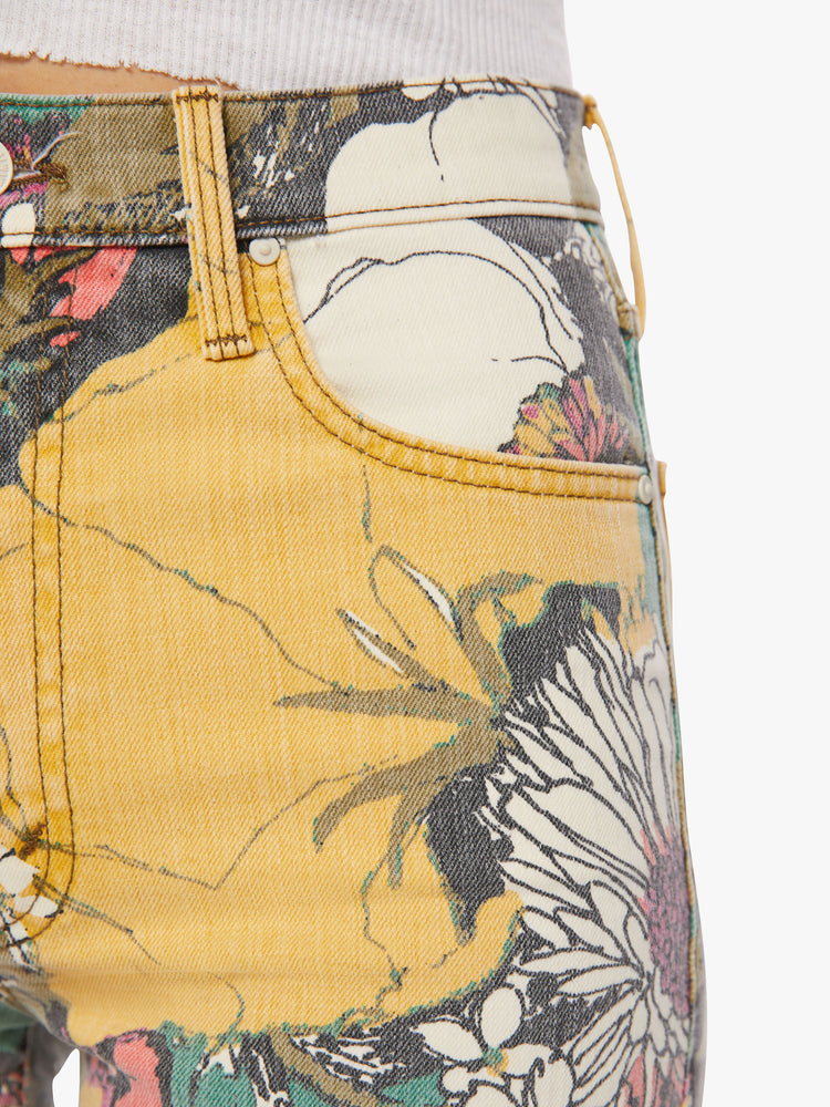 Close up waist view of a woman high-waisted jeans with a wide straight leg, zip fly and clean ankle-length inseam in an oversized floral print.