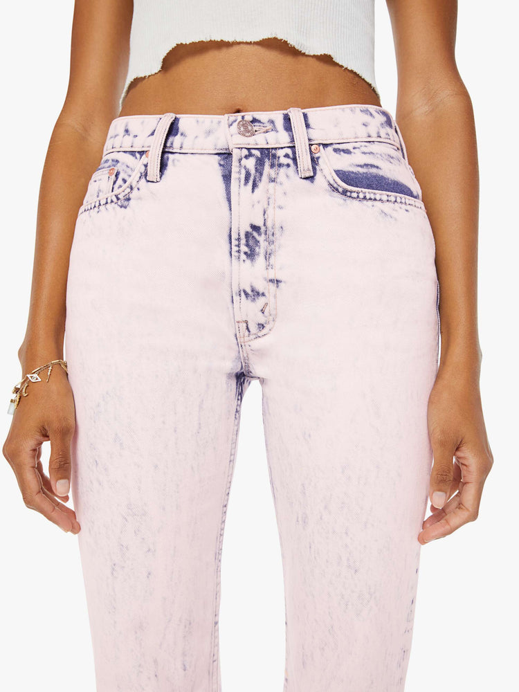 detailed front view of a woman in ankle length jeans that are acid-washed and overdyed in a soft light pink with darker spots throughout.