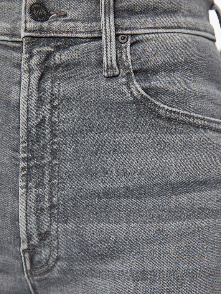 Close up view of a woman high-waisted straight leg with an ankle-length inseam and a clean hem in a faded grey wash.