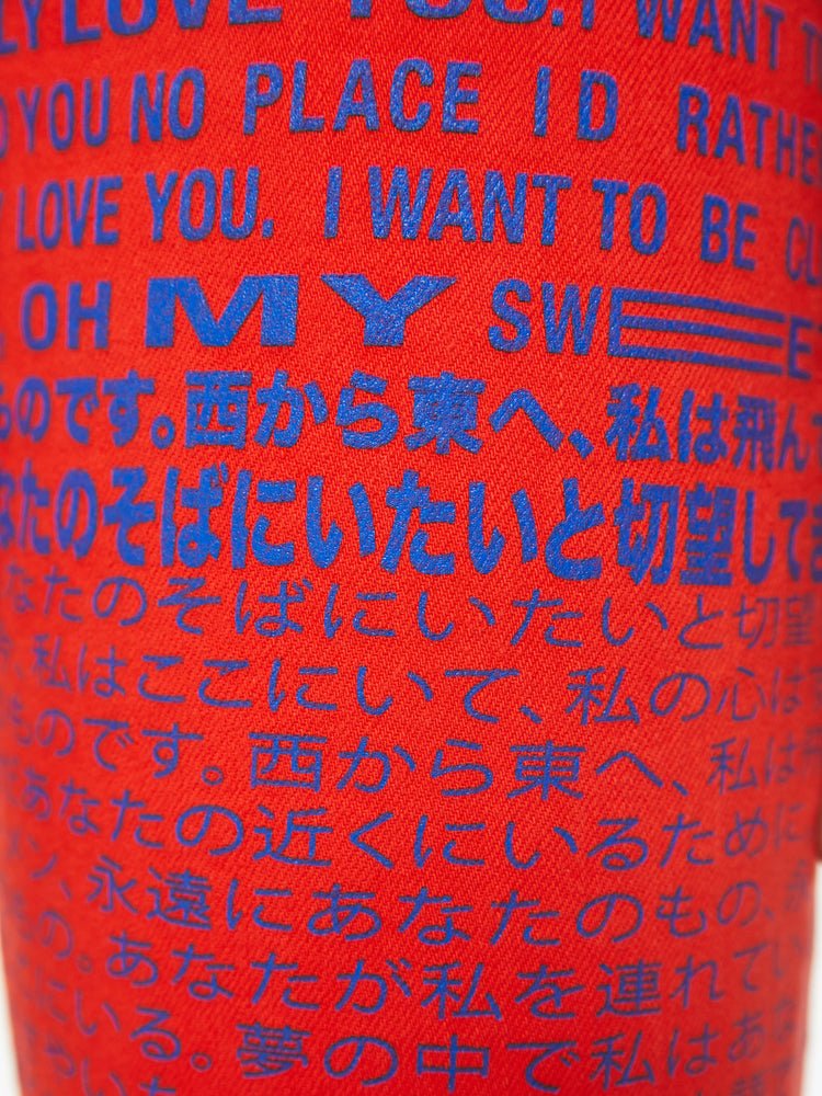 Swatch view of a woman high-rise flare with a button fly and a frayed hem that hits at the ankle in a bright red with blue text.