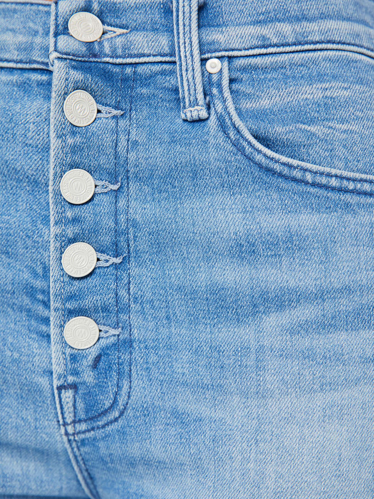 Detailed view of a woman in a light blue high-waisted straight leg jean with an ankle-length inseam, exposed button-fly and a clean hem.