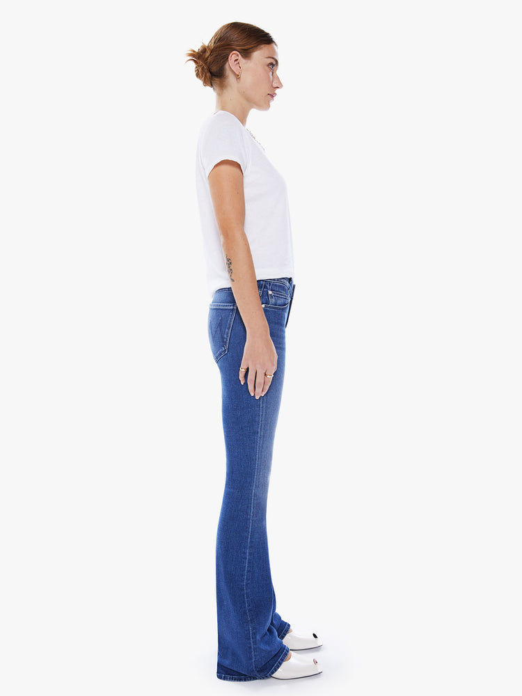 Side view of a woman super low-rise flares have a long 34-inch inseam and a clean hem in an ocean-blue hue.