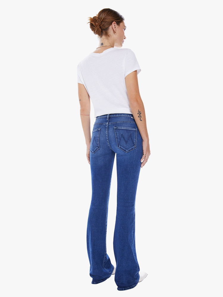 Back view of a woman super low-rise flares have a long 34-inch inseam and a clean hem in an ocean-blue hue.