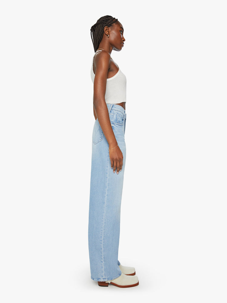 Side view of a woman super high-rise jeans with a loose wide leg, zip fly and a long 34-inch inseam and a clean hem in a light blue denim.