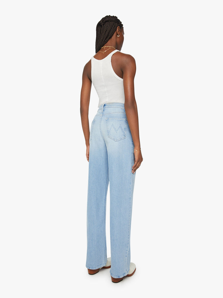 Back view of a woman super high-rise jeans with a loose wide leg, zip fly and a long 34-inch inseam and a clean hem in a light blue denim.