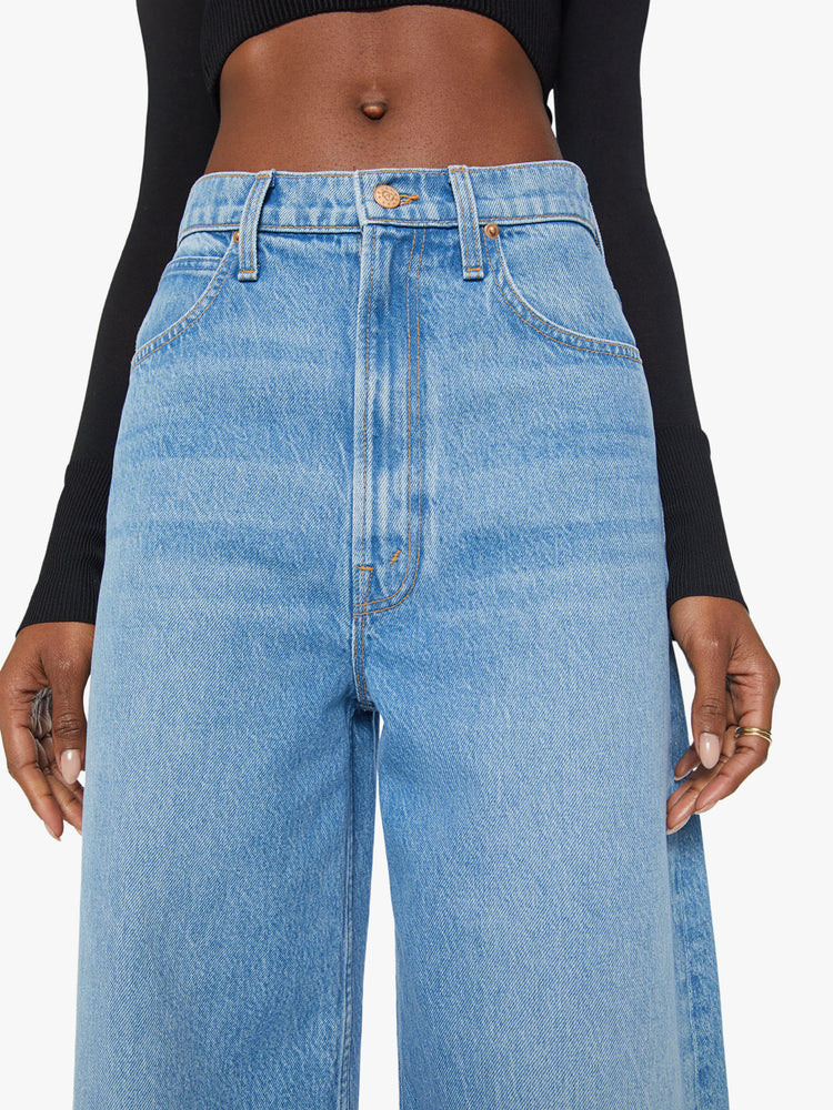 Waist view of a woman super high-rise jeans feature a loose, wide leg and a cropped 26-inch inseam in a light blue wash.