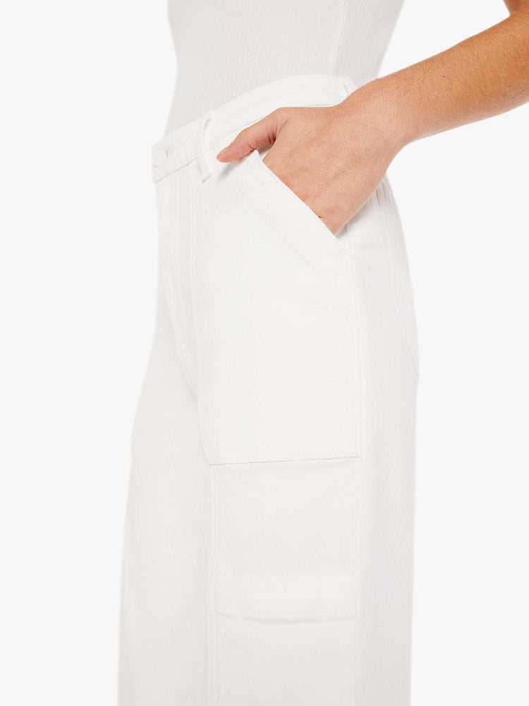 Side close up view of a womens white cargo pant featuring a super high rise and straight leg.
